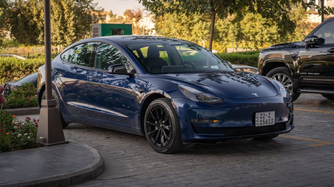 Синя Tesla Model 3 на парковці