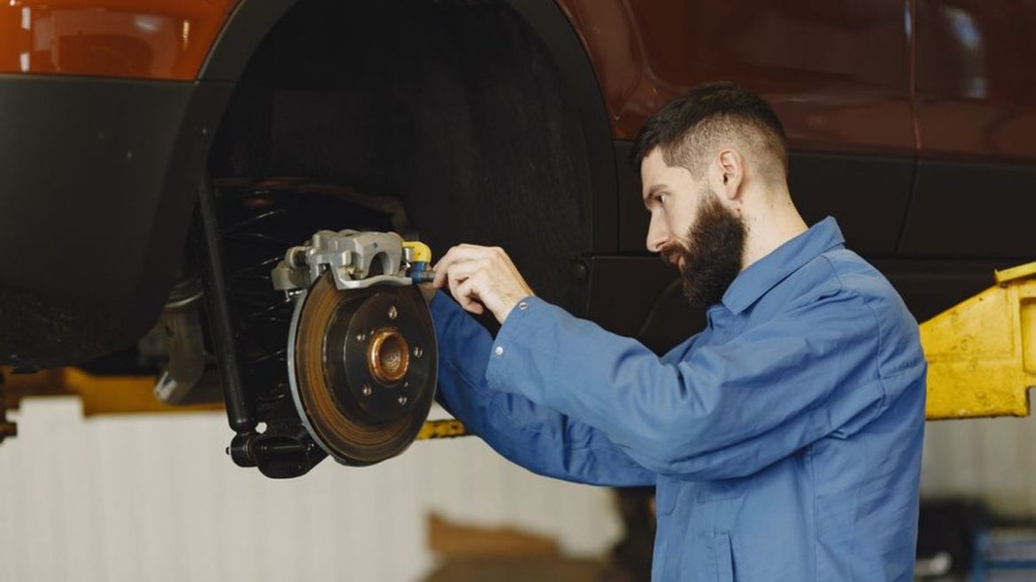 Механік обслуговує гальмівну систему автомобіля