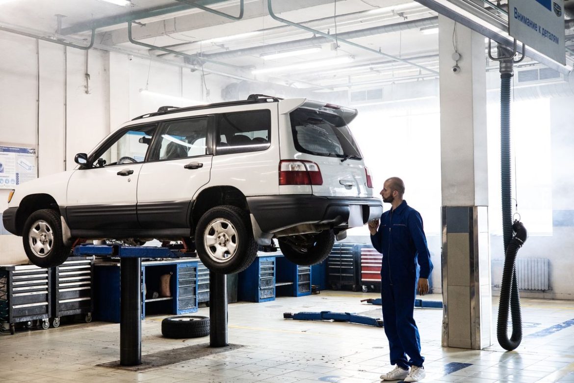 Механік оглядає вживаний автомобіль на підйомнику незалежної СТО перед купівлею